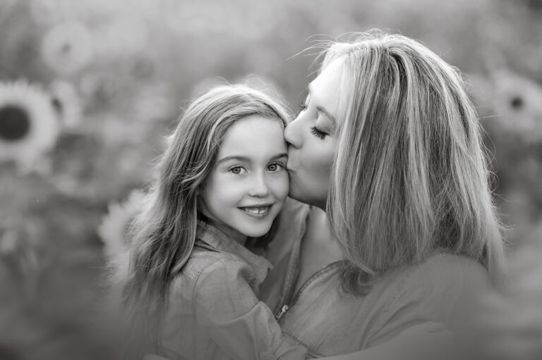 Mother kisses daughter in black and white portrait